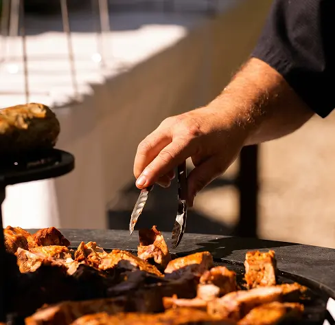 Viandes grillées à la minute sur brasero culinaire pendant l'atelier brasero du traiteur