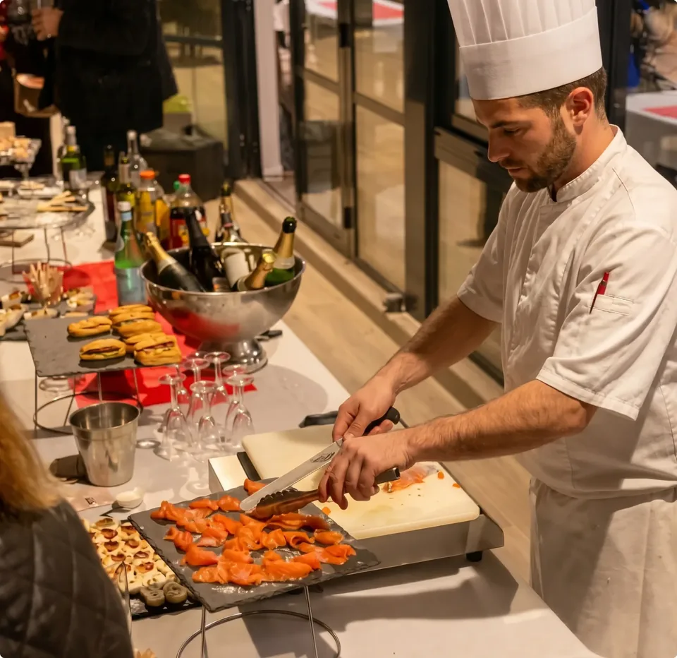 Chef tranchant un gravlax de saumon mariné devant les invités pendant l'atelier culinaire